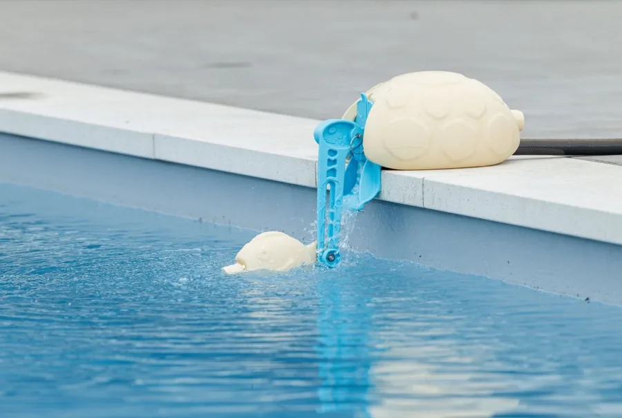 Top-Up Turtle automatic pool water leveler float valve sitting on a pool edge
